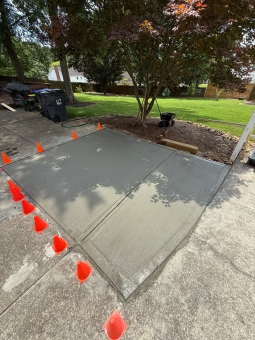 Freshly poured concrete by A.SCAPINGS in Hall County, GA with safety cones